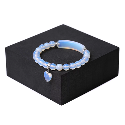 8mm clear quartz bracelet with charm on black stand